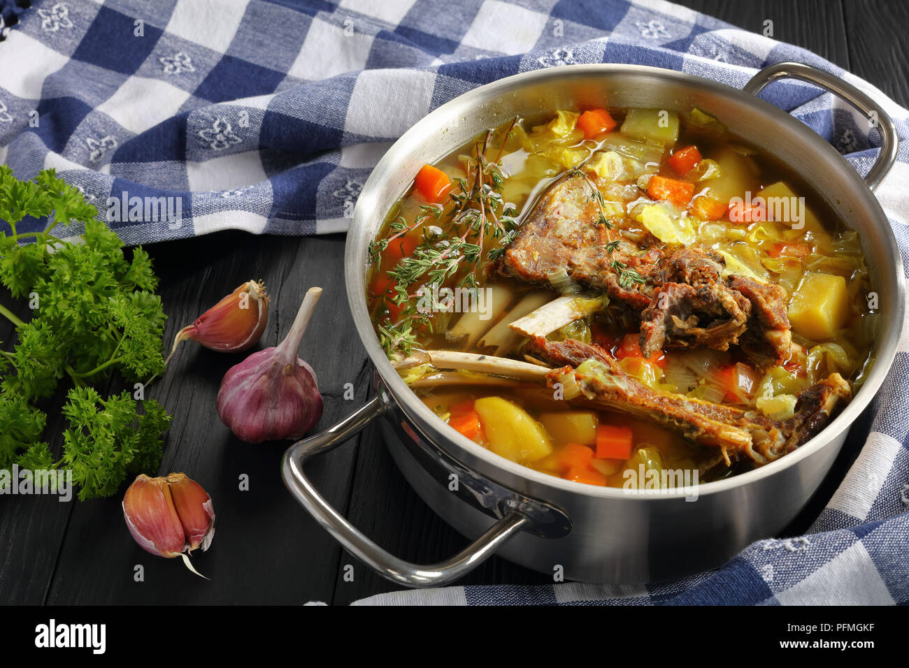 Nahaufnahme der köstliche isländische Lamm Winter heiße Suppe mit Gemüse und Gewürze oder kjotsupa in Edelstahl Kasserolle Pfanne auf Holztisch mit Ki Stockfoto
