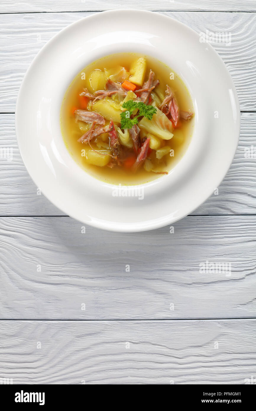Klassische isländisches Lamm Suppe mit Gemüse und Gewürze oder kjotsupa in Soup Bowl auf weissem Holztisch, traditionellen Rezept, Ansicht von oben, close-up Stockfoto