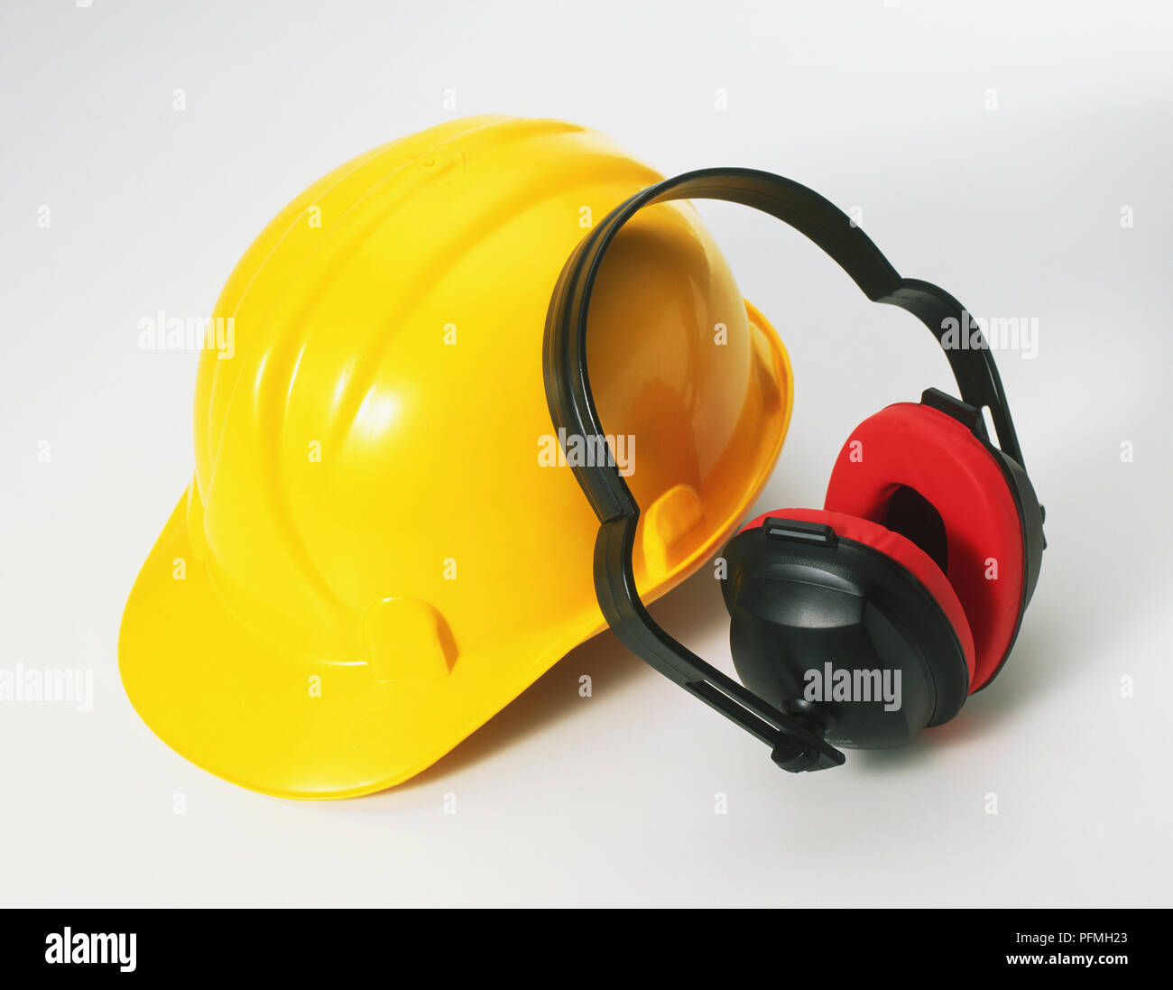 Eine gelbe Bau Schutzhelm und roten und schwarzen Gehörschutz Stockfoto