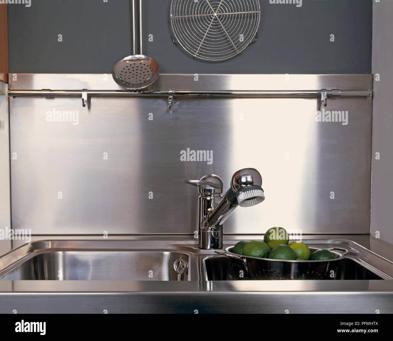 Metall Küche Spüle mit Limes in einem Sieb Stockfoto