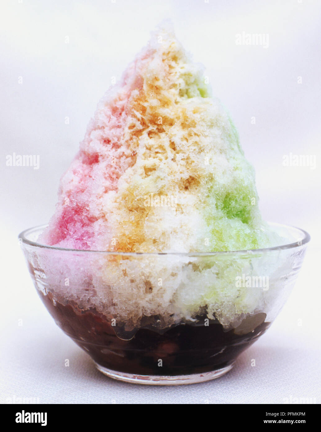 Eis kachang, beliebtes Dessert in Singapur, gesüßte Eis mit Mais, roten Bohnen und Gelee, ähnlich rosa grün-weiß gestreiften Sorbet, dunkle Basis in Glas Teller serviert. Stockfoto