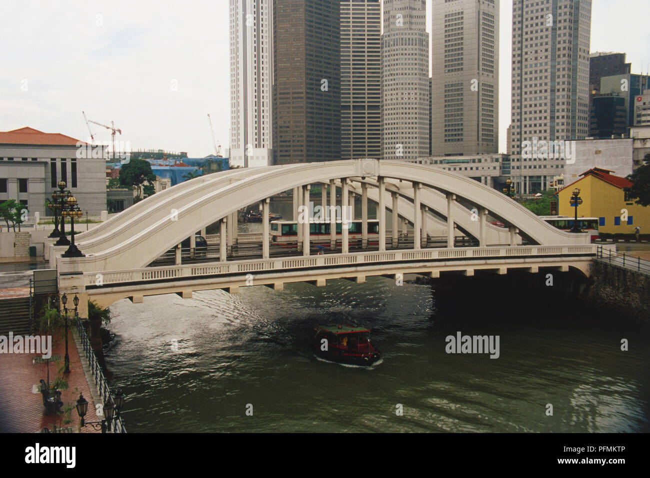 Singapur, Singapur Fluß, Elgin suspension Brücke über den Singapore River, Verkehr Brücke, Boot, unterhalb, hohen grauen Hochhäusern im Hintergrund. Stockfoto
