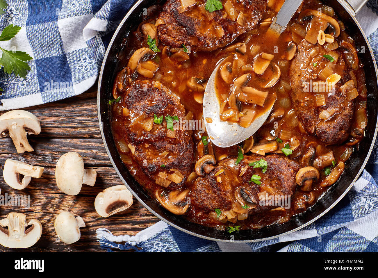 Salisbury heißen herzhaften saftige Rindersteaks mit köstlichen Pilz Soße Zwiebel in einer Pfanne mit Sauce Löffel, Ansicht von oben, close-up Stockfoto