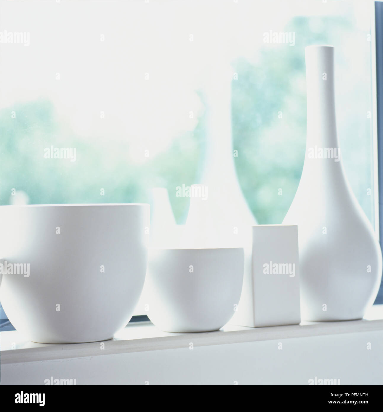 Weißer Keramik Töpfe und Vasen auf der Fensterbank. Stockfoto