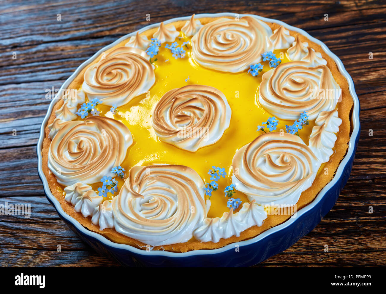 Klassische lemon tart - köstliche, frische Backwaren mit einer glatten  Zitrone Füllung mit Baiser Rosen und genießbaren frischen Blumen, Ansicht  von oben, in der Nähe Stockfotografie - Alamy