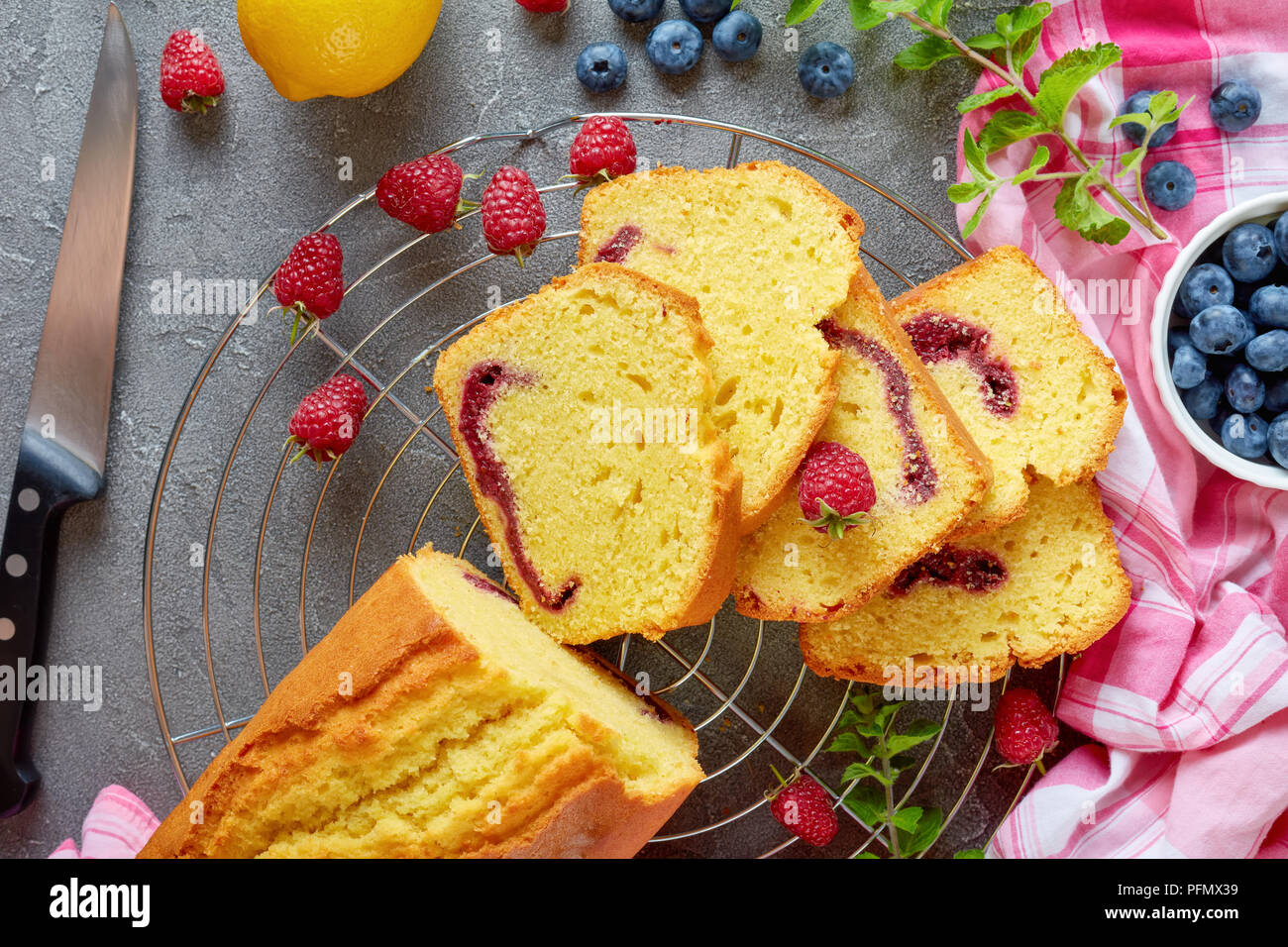 Frisch gebackene Scheiben geschnittenen Zitrone Pound Cake mit Beeren marmelade Füllung auch als Torte de voyage Kuchen auf einen konkreten Hintergrund mit Inhaltsstoffe bekannt, französisch c Stockfoto