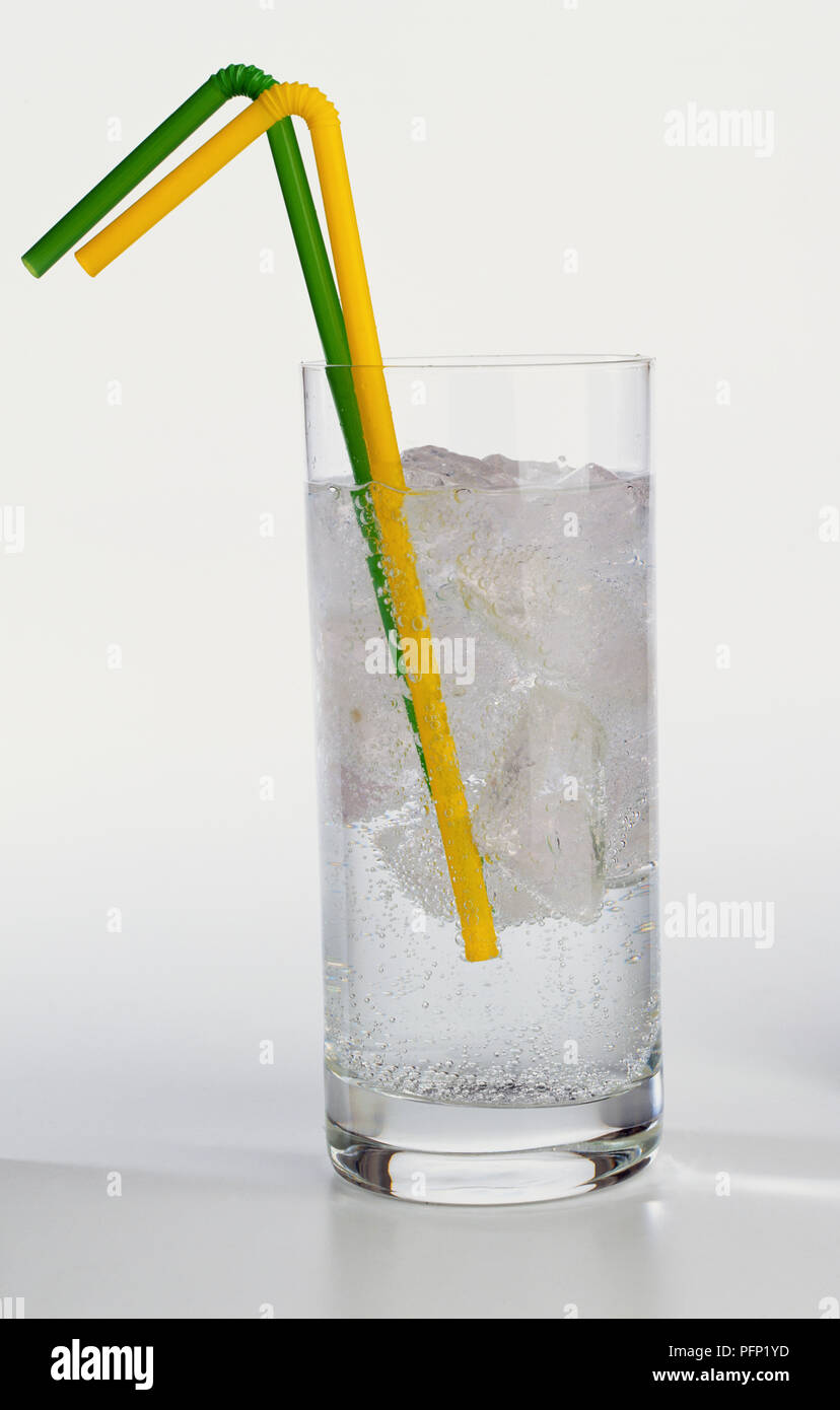 Gelb und grün Pailletten in Glas voller sprudelnder Wasser und Eiswürfel. Stockfoto