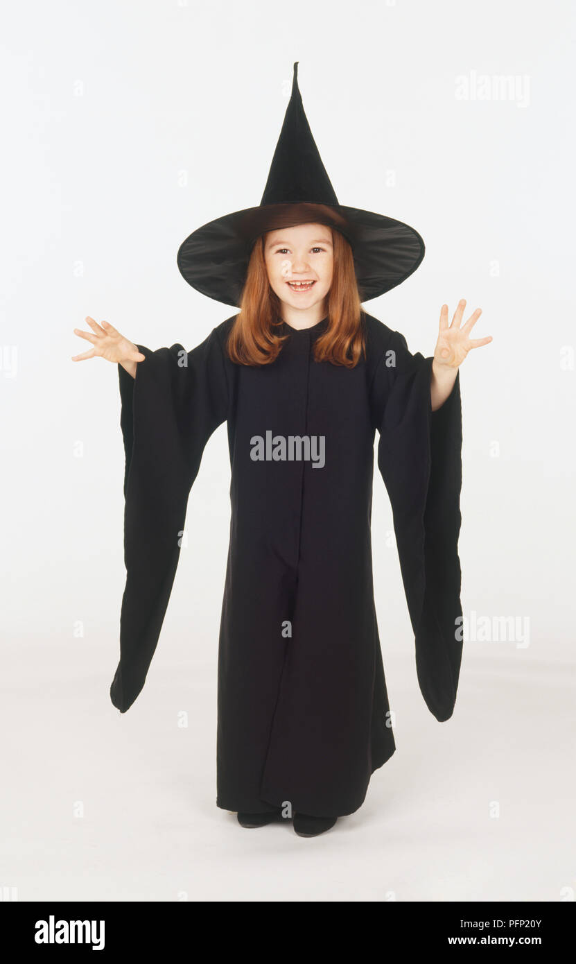 Mädchen in schwarzen spitzen Hut Hexe und Mantel, hob die Hand, an der Kamera auf der Suche Stockfoto