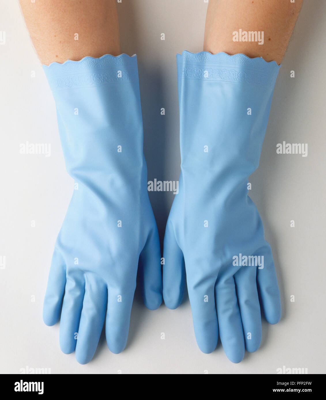 Hände von Person tragen ein Paar blaue Gummihandschuhe, Ansicht von oben. Stockfoto