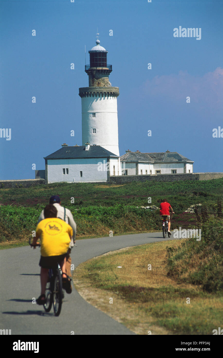 Frankreich, Bretagne, Finistère Nord, Ouessant, Phare du Steif, Besucher Radfahren in Richtung weiß getünchten Leuchtturm von Vauban im Jahre 1695 gebaut. Stockfoto
