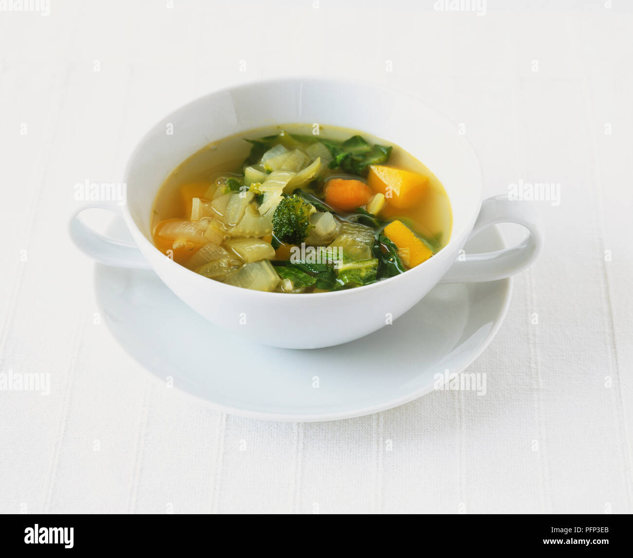 Chunky Gemüsesuppe serviert in zarten weißen Schale auf der Untertasse Stockfoto