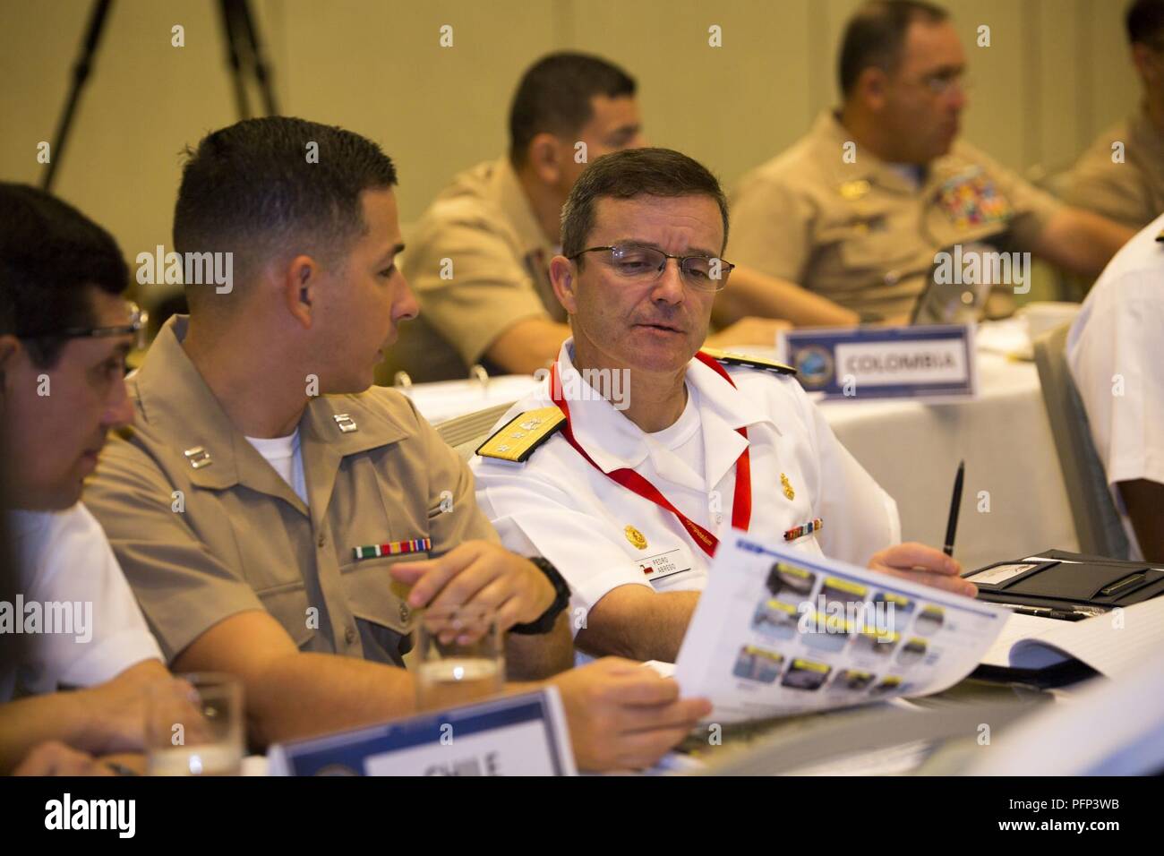 Us Marine Corps Kapitän Andres Vasquez, Links, stellvertretender Personal Judge Advocate, US Marine Corps Forces, Süden, übersetzt der chilenischen Marine Corps hinten Adm. Pedro Ábrego Martínez, Kommandierender General, die chilenische Marine Corps, während der Pazifik amphibischen Führer Symposium (PALS) 2018 in Honolulu, Hawaii, 23. Mai 2018. Während des Symposiums, militärischen Dienstleistungen aus der ganzen Welt eine engere militärische Bindung mit einem anderen bauen. Engere Bande zwischen anderen Militärs erleichtern klare Kommunikationswege und den Geist der Zusammenarbeit Potential für globale Herausforderungen zu fördern. Stockfoto