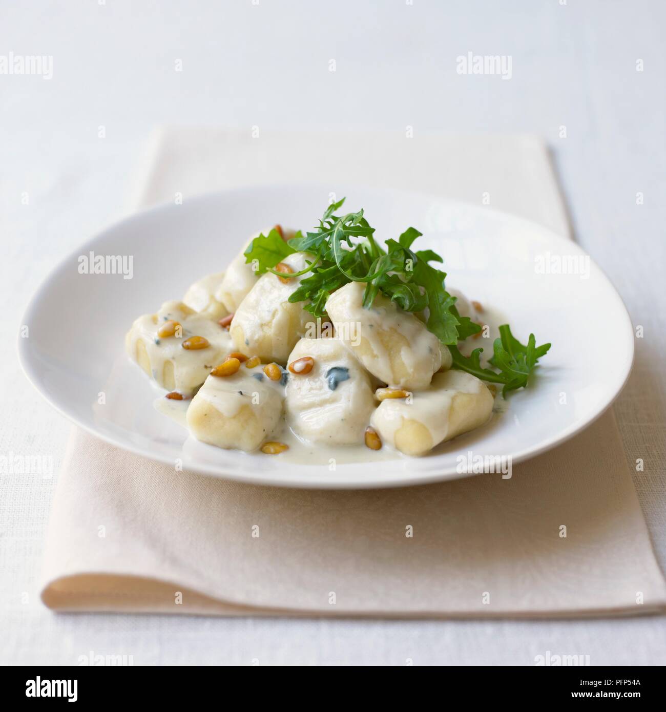 Gnocchi serviert mit grünem Salat Blätter auf weiße Platte Stockfoto