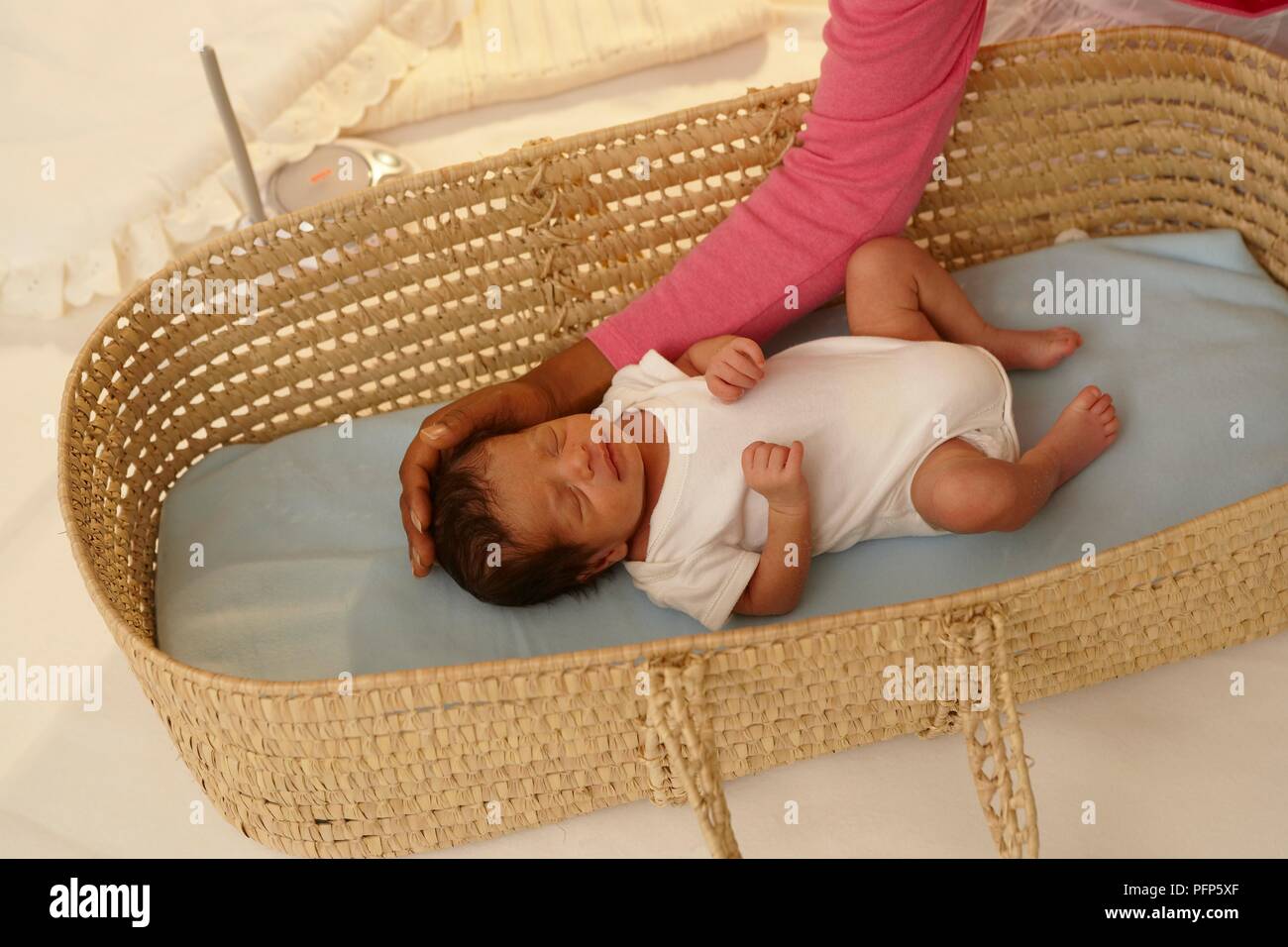 Baby Moses Korb, die Hand der Frau seinen Kopf streicheln Stockfoto