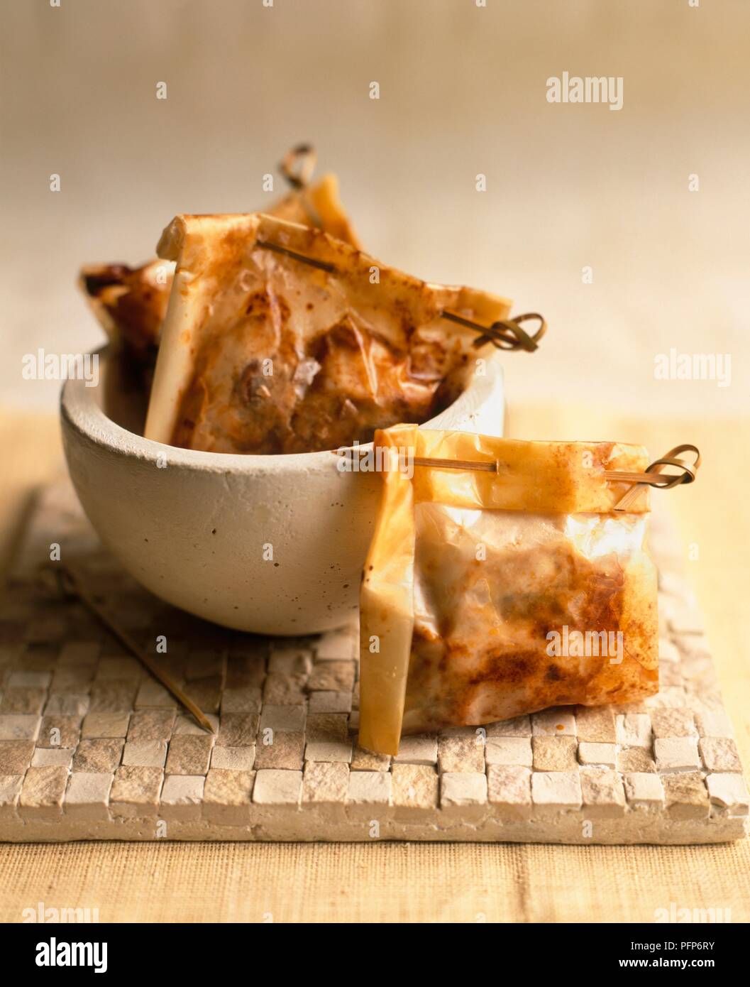 Chee pow Kai, Malaysische frittiert, Papier - Huhn aus Steingut Schale umhüllt, und auf eine Kachel Stockfoto