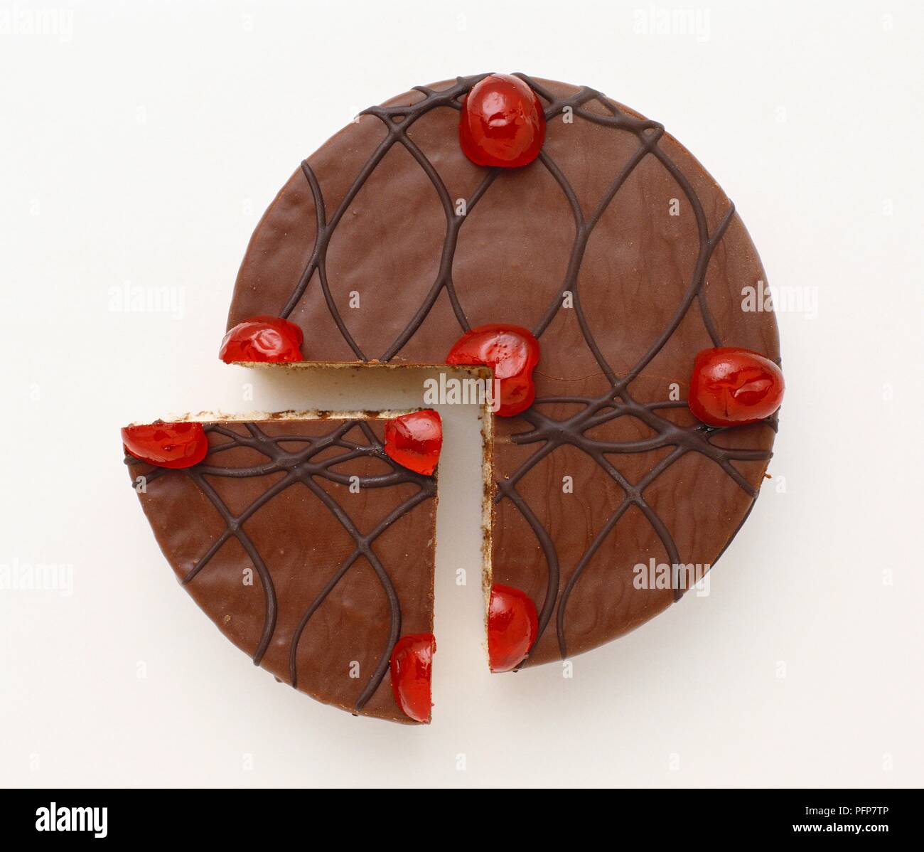 Schokolade Kuchen und Slice gekrönt mit Muster und roten Kirschen Stockfoto