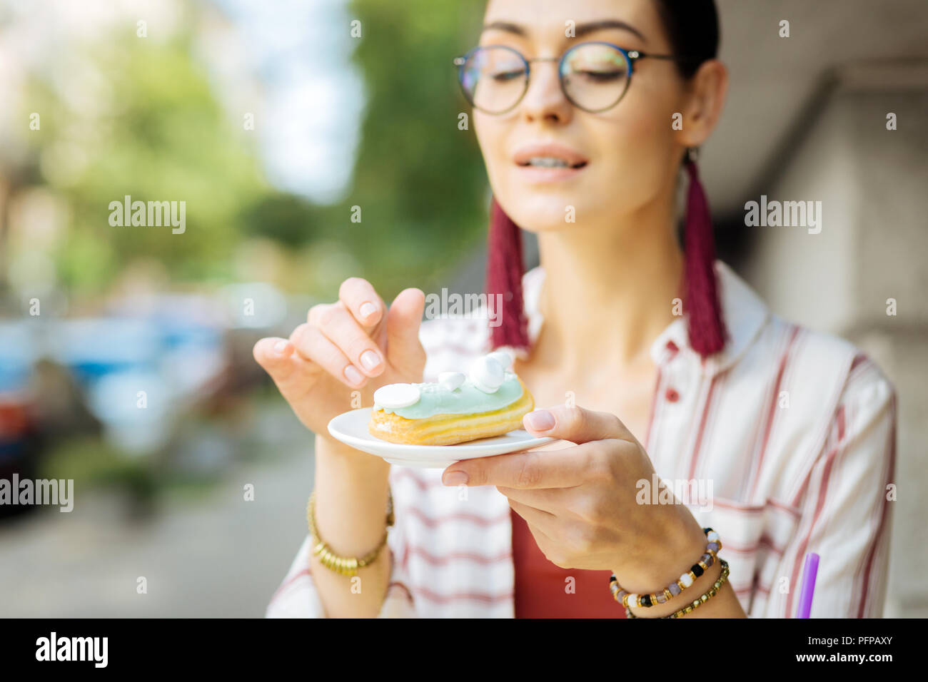 Ruhige Frau mit einer Platte und einem Blick auf das Dessert auf es Stockfoto