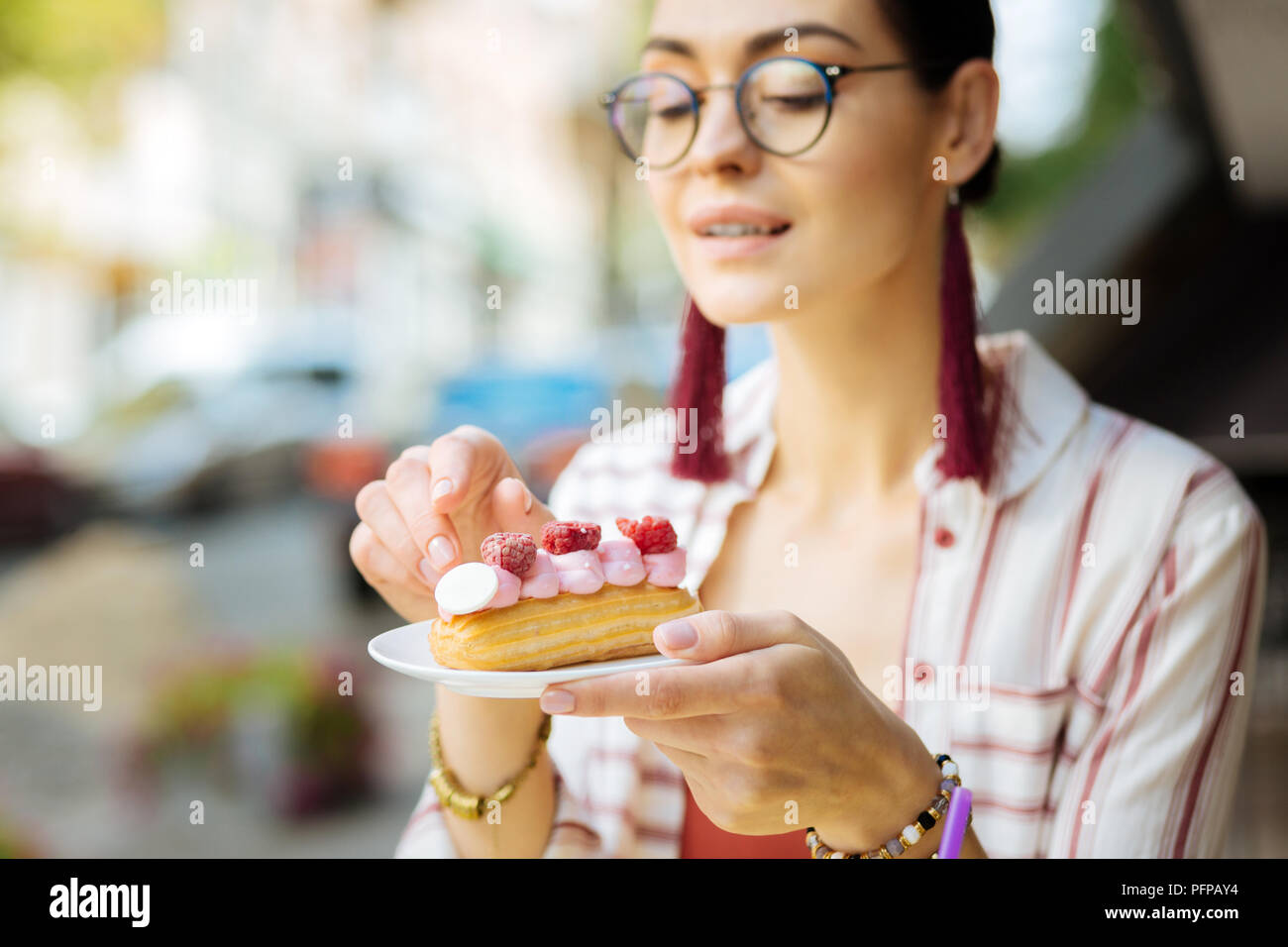 Lächelnde Frau an der Raspberry Dessert suchen vor dem Essen es Stockfoto