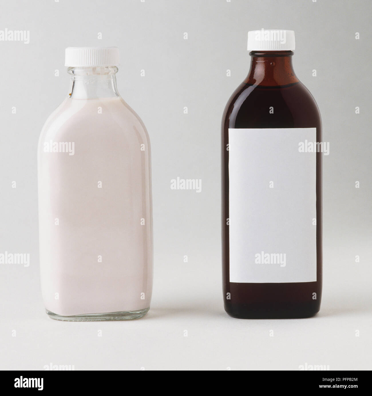 Klares Glas Flasche mit weißer Lotion und braunen Glasflasche mit leeres Etikett mit Sirup gefüllt. Stockfoto
