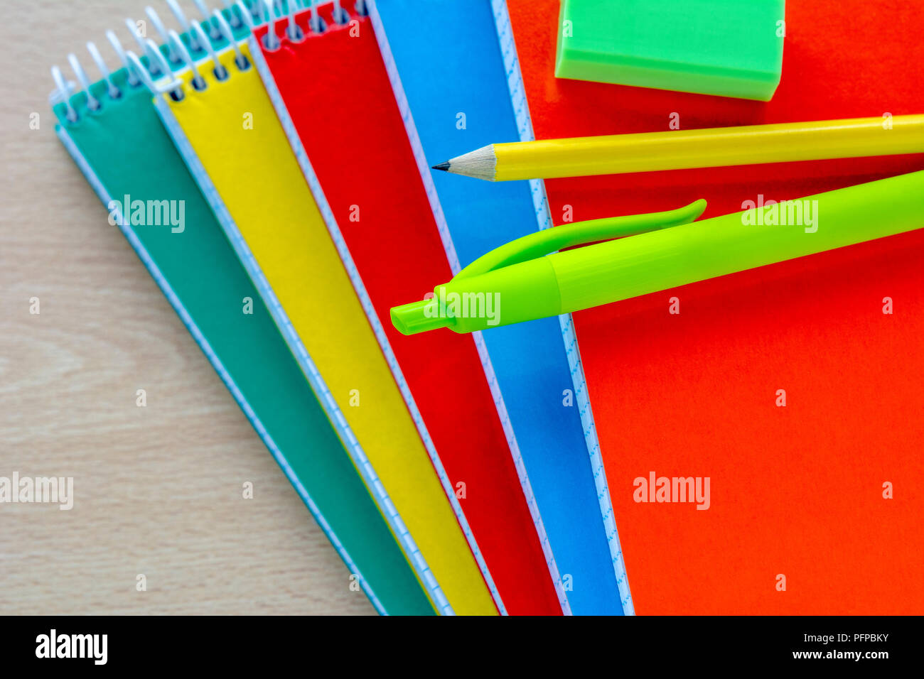 Zurück Konzept zur Schule, Schulbedarf, Blick von oben auf die bunten Schreibblock und Bleistift Stockfoto