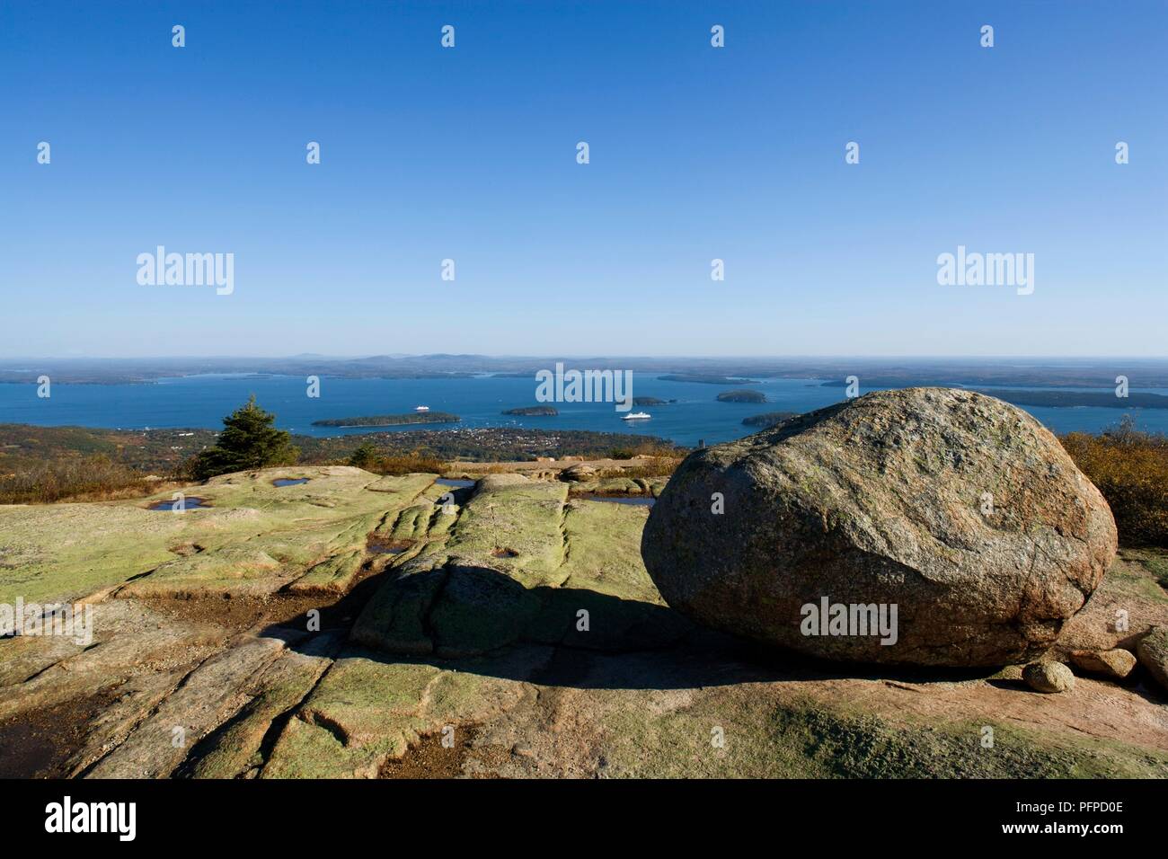 USA, Maine, Mount Desert Island, Acadia National Park, Cadillac Mountain, Boulder auf glazialen Rock formatiom mit Blick auf die Bar Harbor in der Entfernung Stockfoto