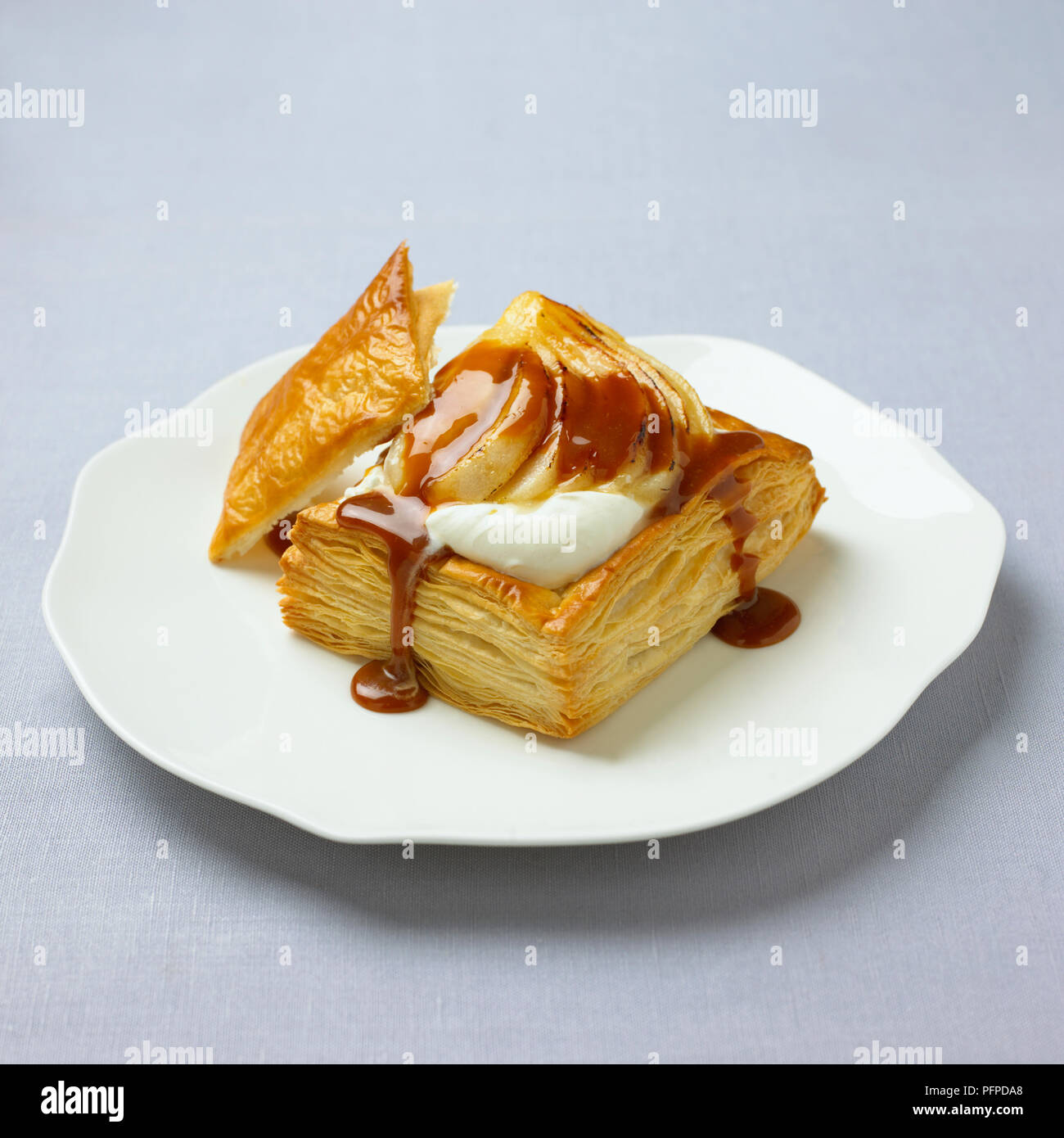 Birne und Creme Blätterteig Torte mit Sirup auf weiße Platte Stockfoto
