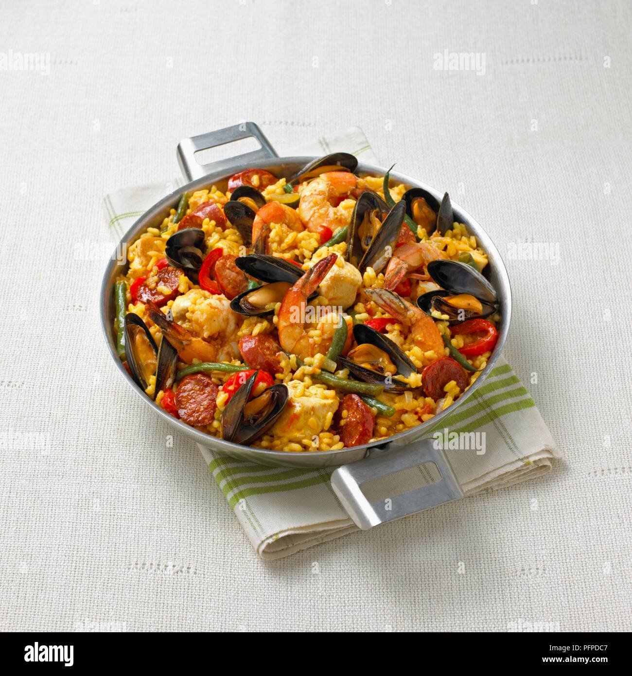 Meeresfrüchte Paella serviert in Metall Servierschüssel auf gefaltete Serviette Stockfoto