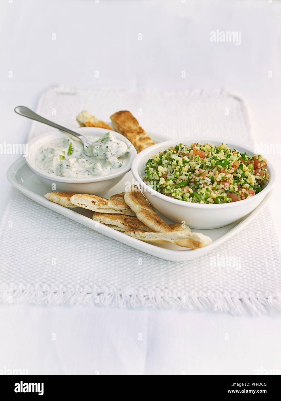 Tabbouleh und dip in Schalen mit libanesischen Brot auf Serviette serviert. Stockfoto