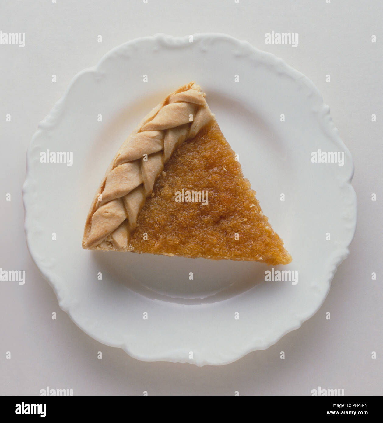 Scheibe treacle Tart mit geflochtener Kruste auf Weiß Dessertteller Stockfoto