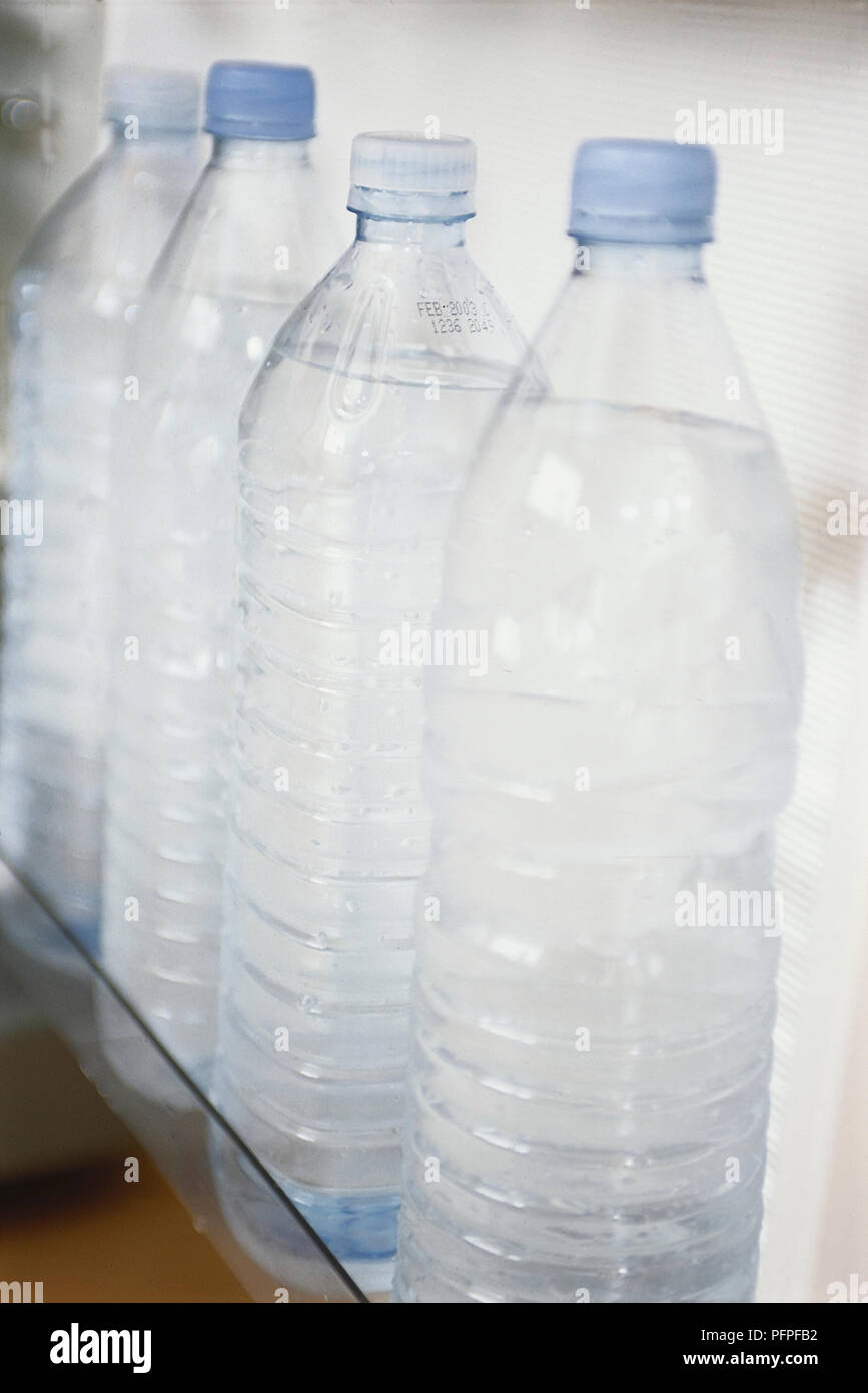 Kunststoffflaschen mit Wasser im Kühlschrank Tür gesäumt recycelt. Stockfoto