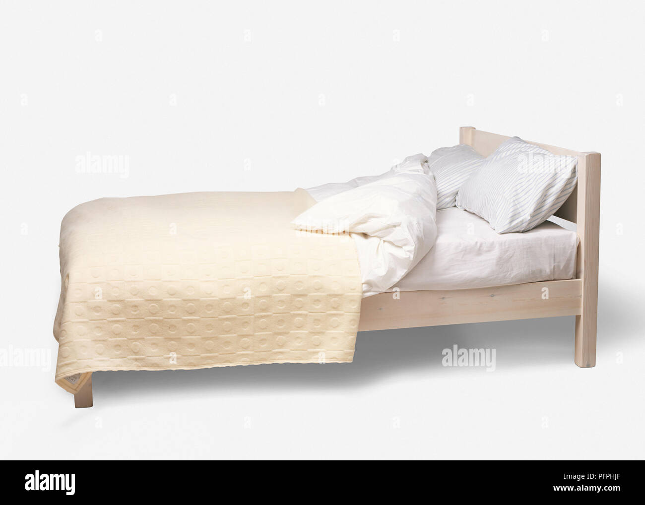 Doppelbett mit einfachen Holzrahmen, Bettdecken, Kissen, Bettwäsche und Bettdecke gefaltet zurück Stockfoto