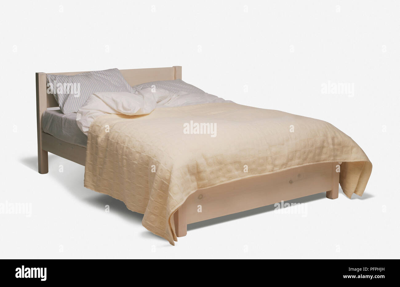 Doppelbett mit einfachen Holzrahmen, Kissen, Bettdecke und Creme bett Abdeckung Stockfoto