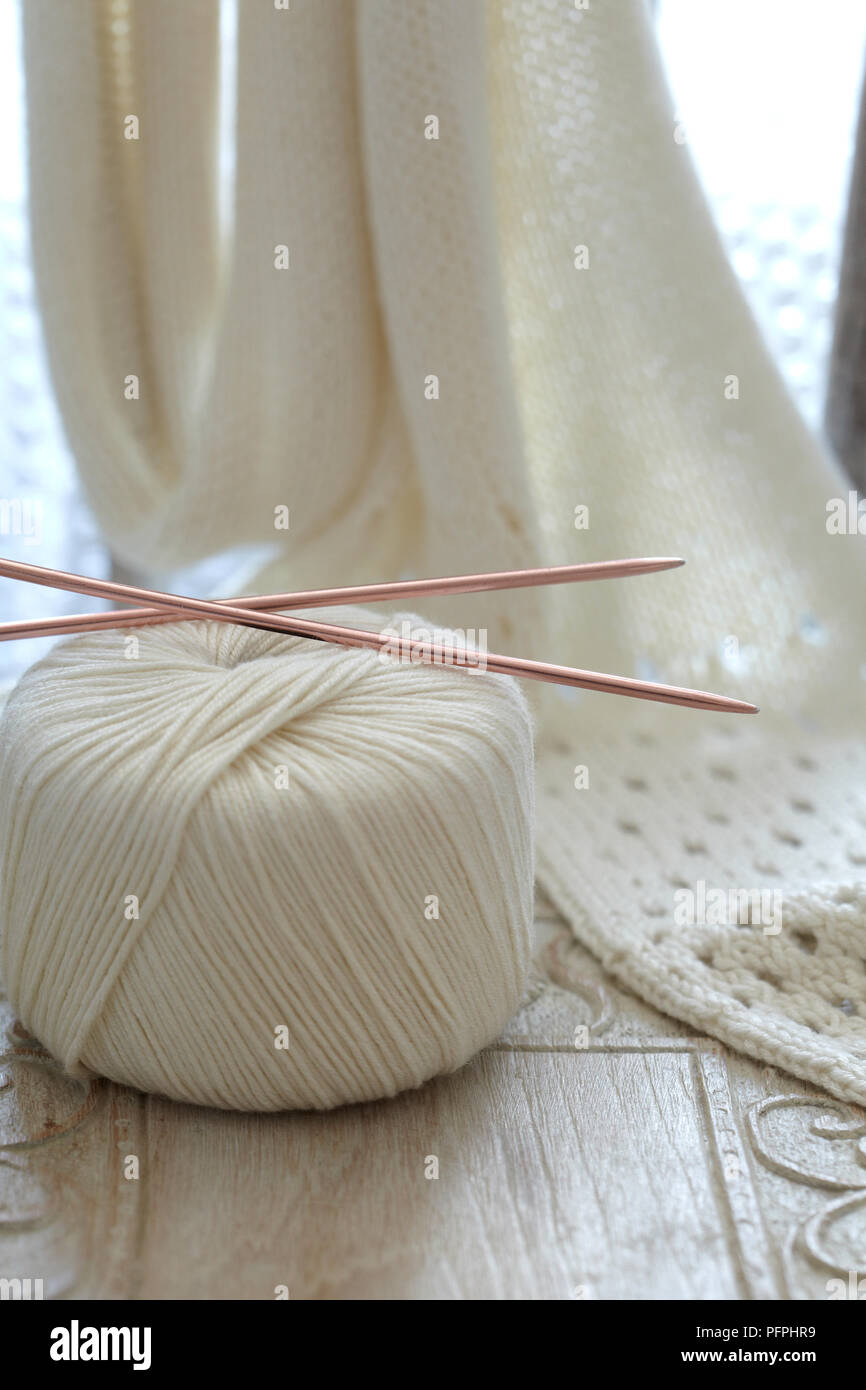 Öse stitch Schal und Kugel aus Wolle mit Stricknadeln, close-up Stockfoto