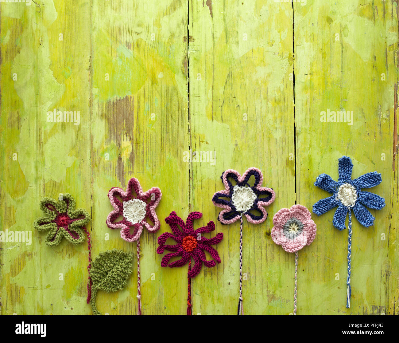 Gestrickte Blumen auf grünem Hintergrund Stockfoto