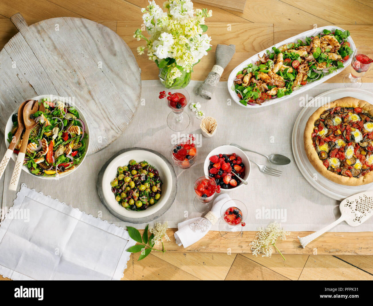Auswahl an mediterranen Gerichten, Meeresfrüchten, halloumi Salat Salat, Oliven und herzhaften Brioche tart, Sommer Beeren, auf Tisch im Freien Stockfoto