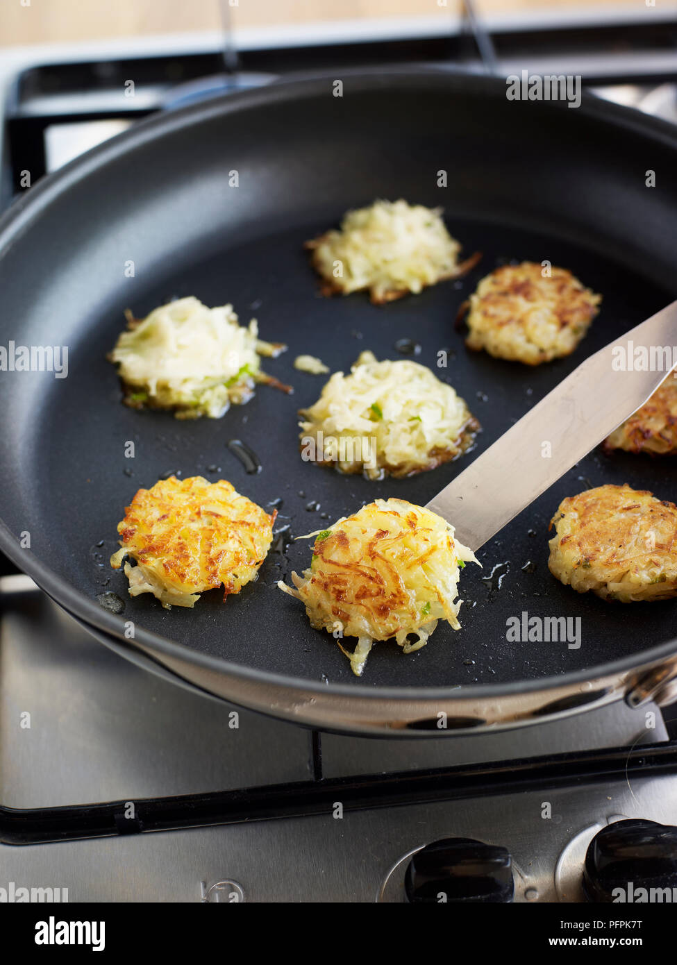 Braten Krabben - mangetout Roesti (rösti) in der Pfanne mit einem Spachtel umdrehen Stockfoto