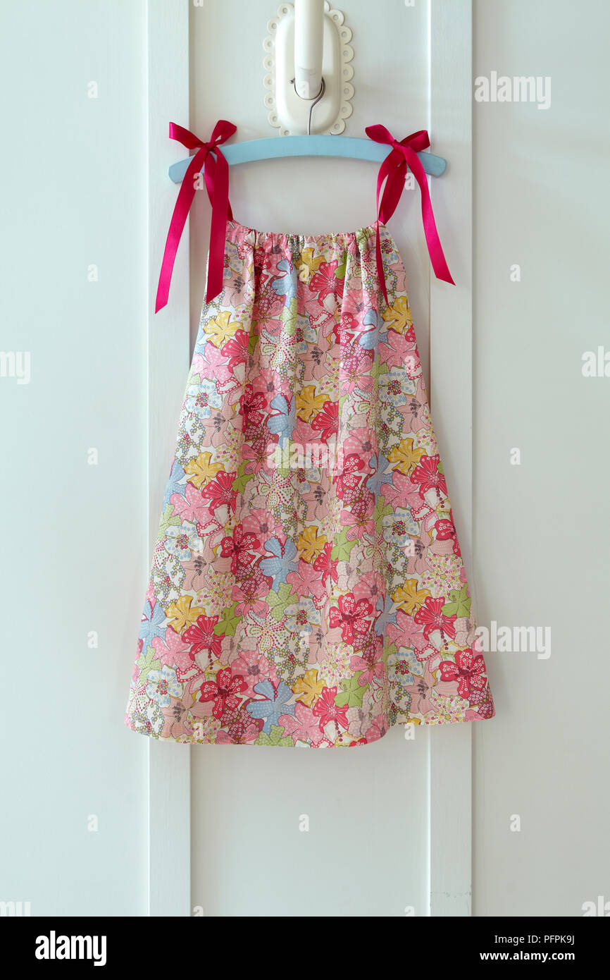 Bunte, mit Blumen gemusterte Girl's Kleid auf Kleiderbügel Stockfoto