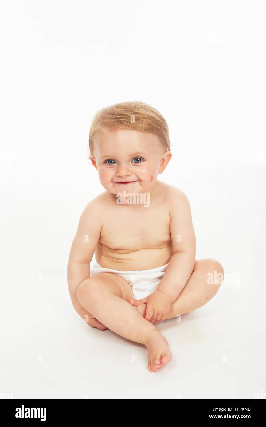 Baby in Windeln sitzen (Modell Alter - 9 Monate) Stockfoto