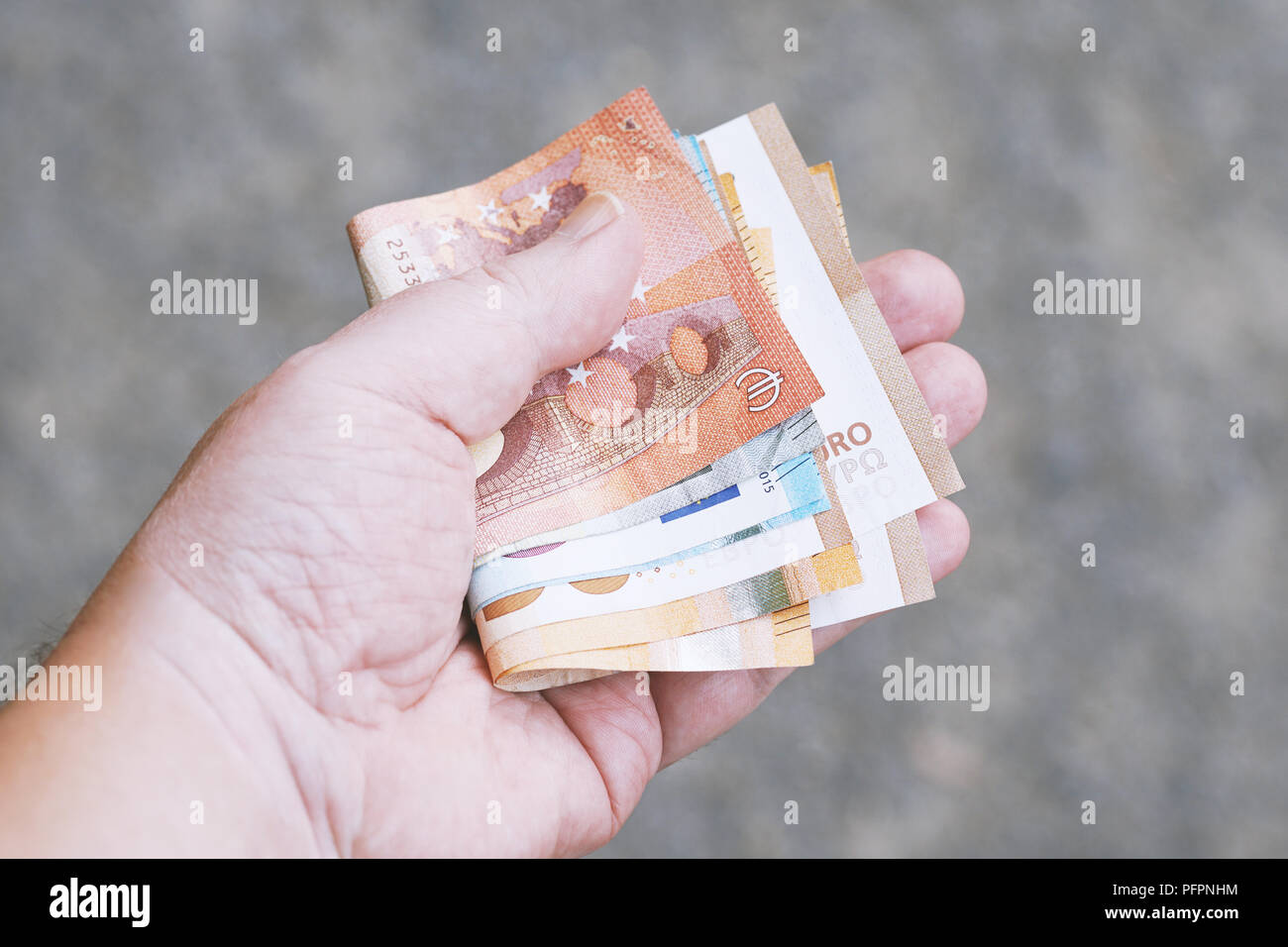Hand, die eine Handvoll Euro Banknoten, Geld Finanzen Geschenke kaufen Ausgaben oder Kaufkraft Konzept Stockfoto