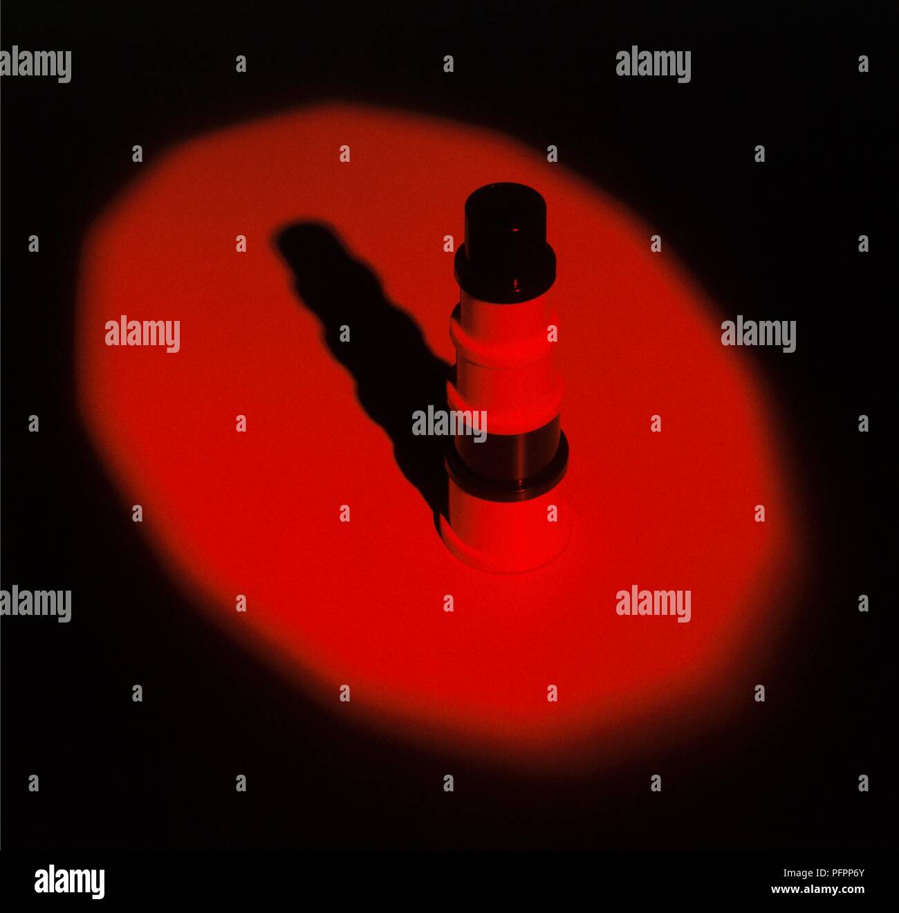 Rotes Licht scheint auf Objekt in dunklen, schwarzen Schatten Stockfoto