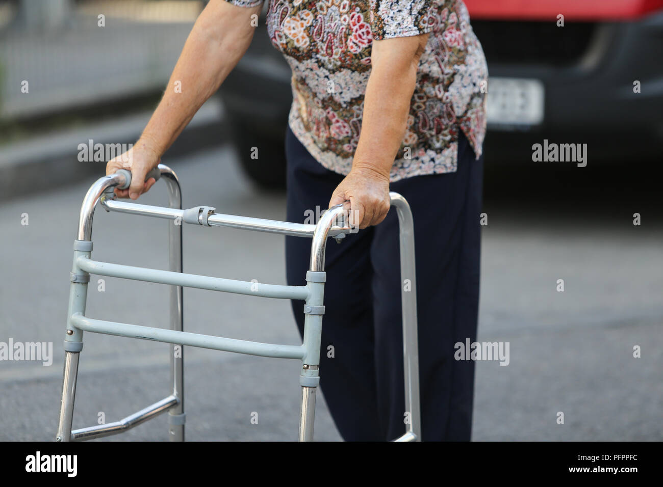 Ältere Frau zu Fuß mit Hilfe einer Metall Walker Stockfoto