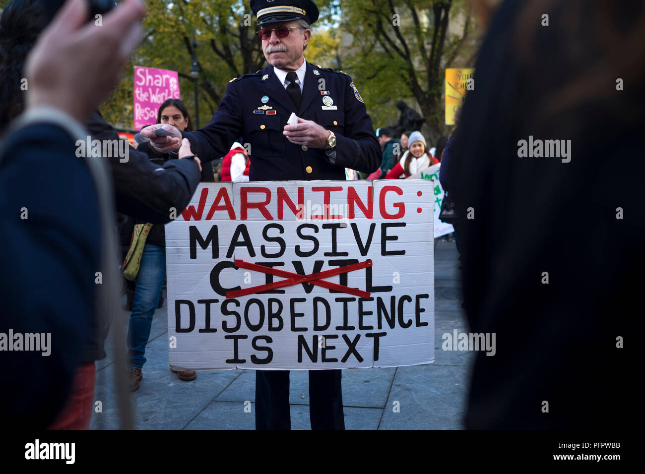 New York City, USA. 11. November 2015: ein Mann in Uniform hält ein Zeichen und gibt Visitenkarten während des globalen Klimawandels ma Stockfoto