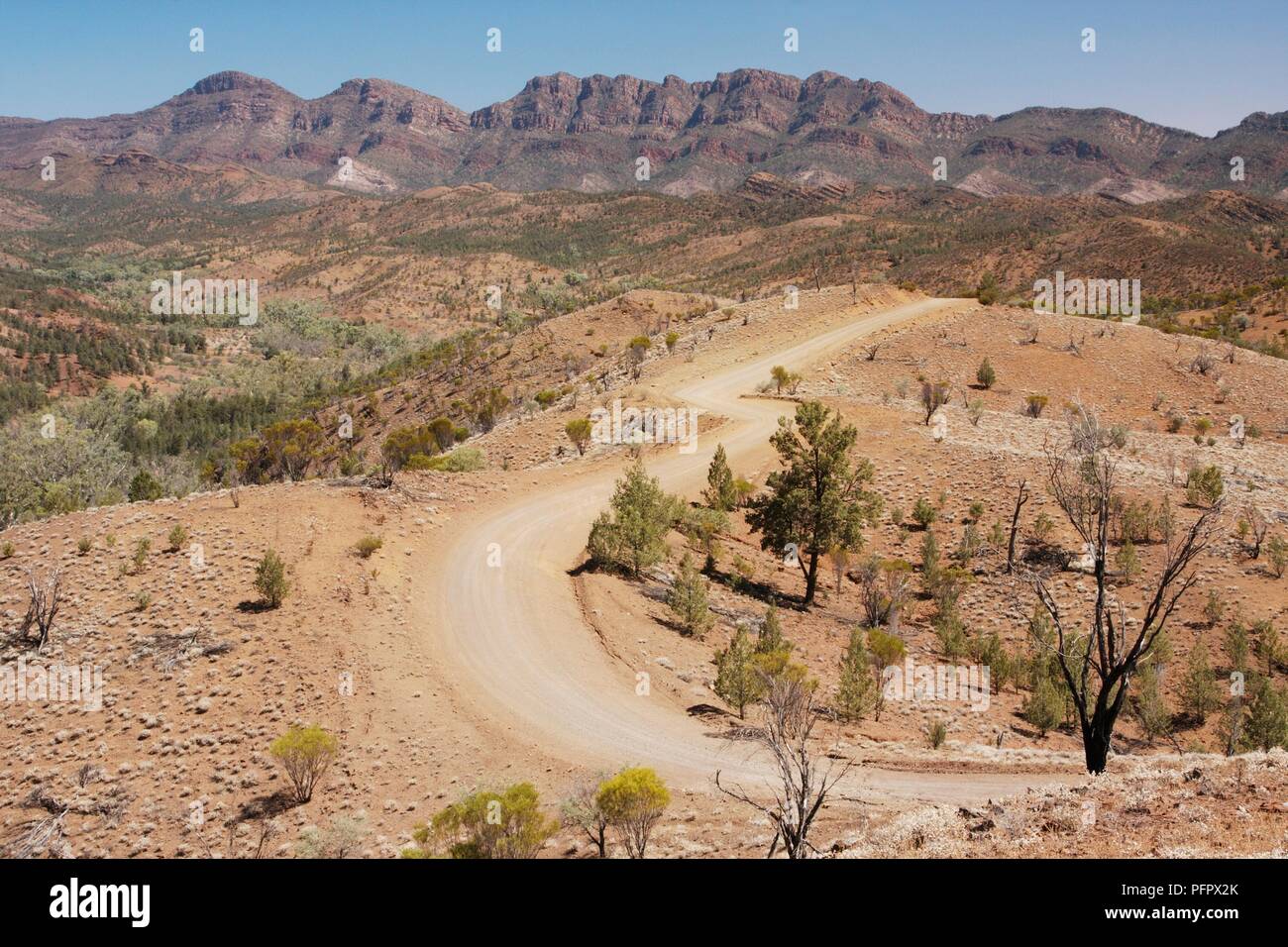 Australien, Flinders Ranges, Straße, Wicklung durch aride Terrain mit Mountain rage im Hintergrund Stockfoto