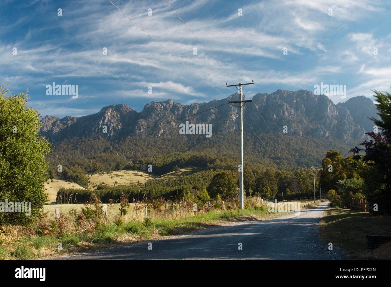 Australien, Tasmanien, Berg Roland, Straße und Telegraphenmast mit Gebirge im Hintergrund Stockfoto