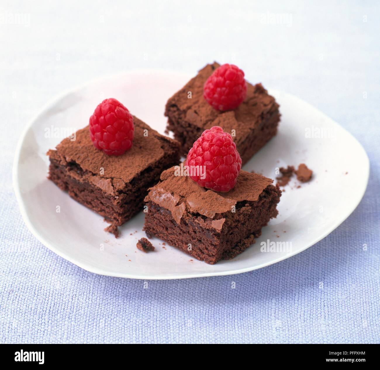 Himbeeren auf drei Scheiben Schokolade Kuchen Stockfoto