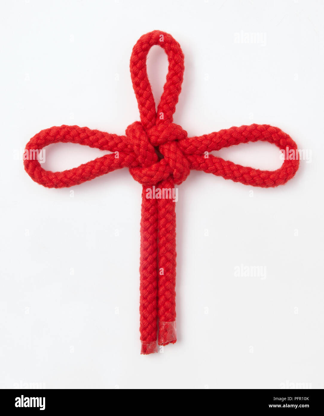 Sailor's Kreuz, dekorativen Knoten in roten Seil gebunden Stockfoto