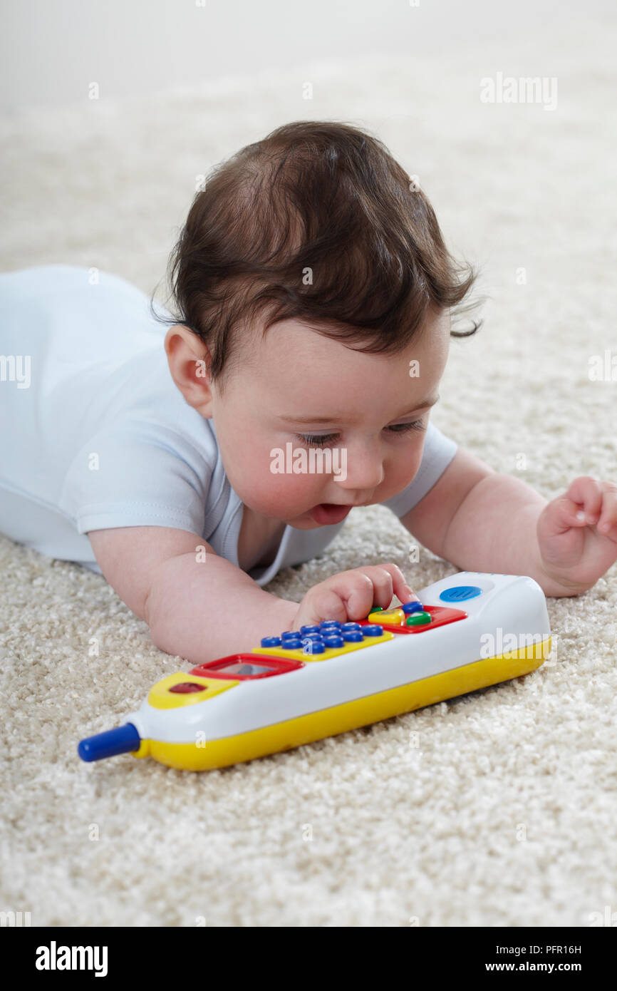 Baby (6 Monate) spielen mit Spielzeug Telefon Stockfoto