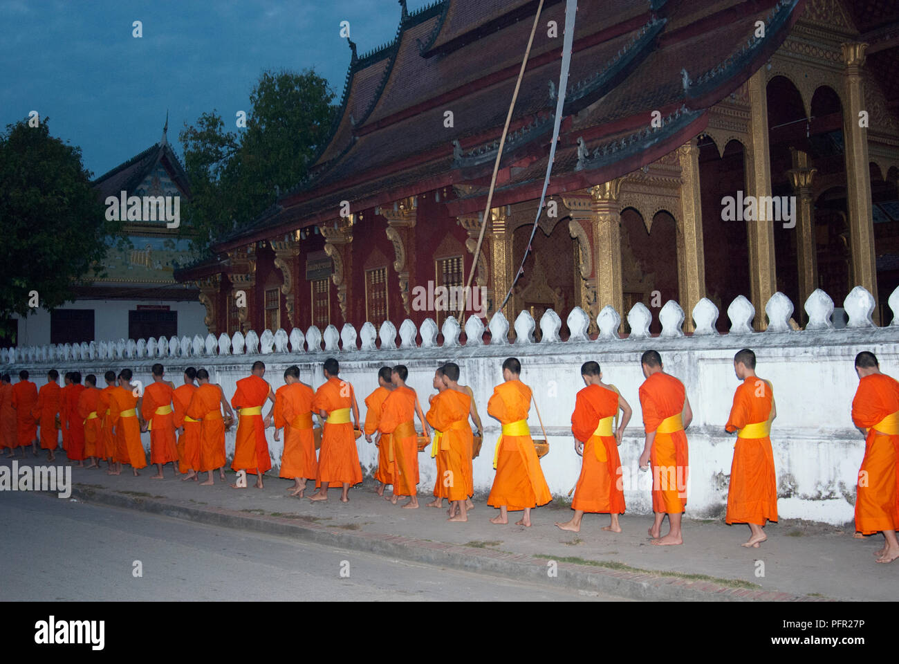 Laos, nördlichen Laos, Luang Prabang (Luang Phabang), buddhistische Mönche auf tägliche Almosen Runde auf Thanon Sisavangvong Straße, Dawn Stockfoto