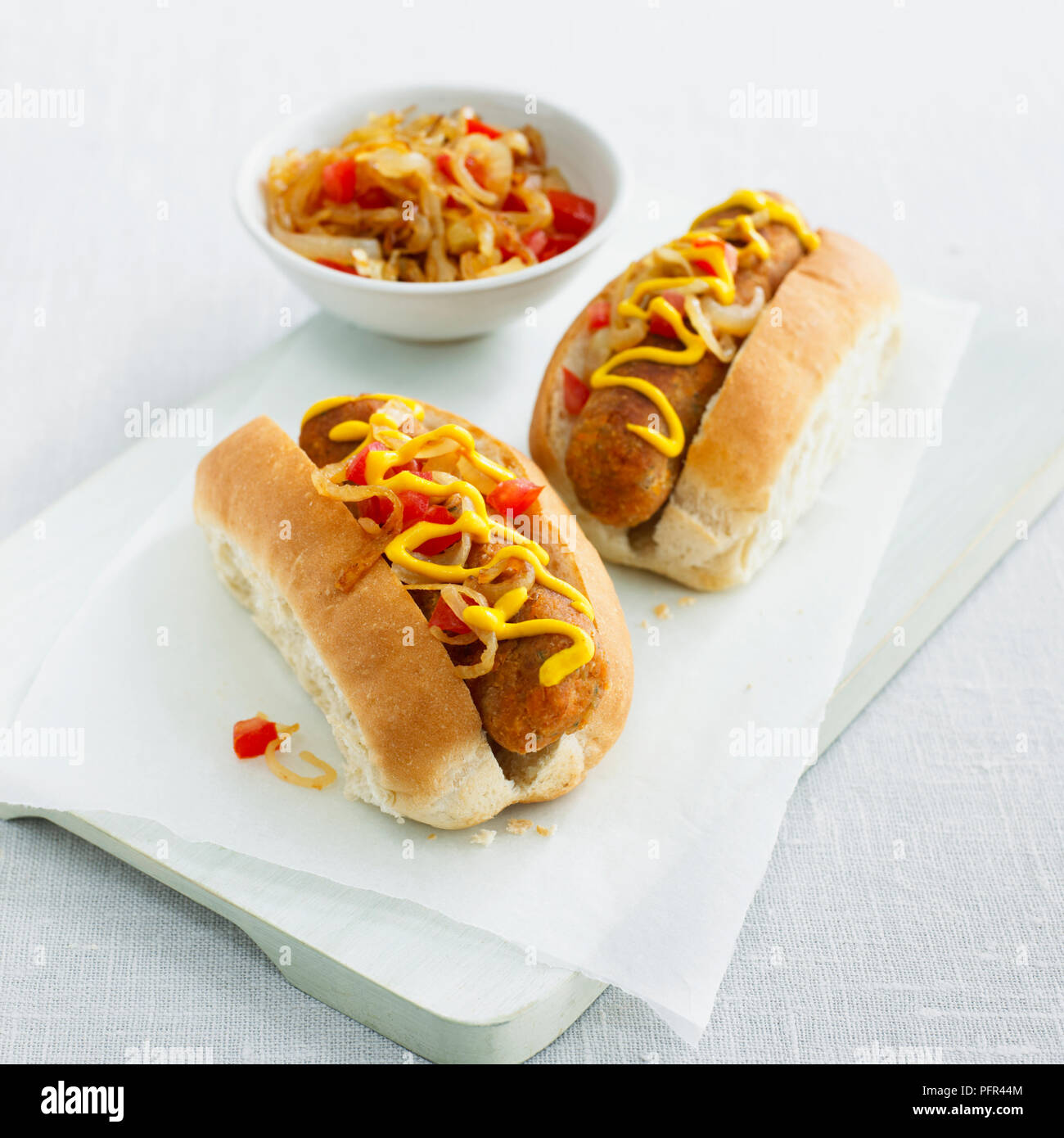Möhre, Zwiebel und Stilton veggie Hot Dogs mit gebratenen Zwiebeln, Tomaten, Senf und gehackt Stockfoto