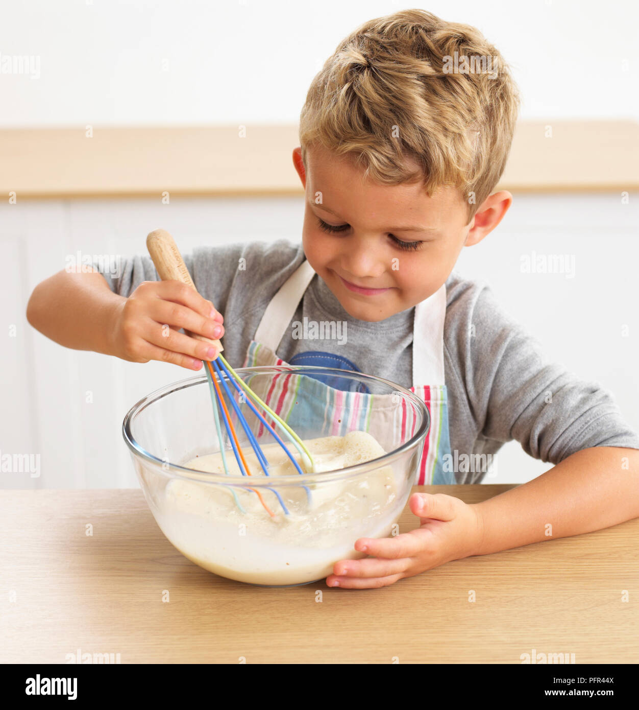 Dass nelly Brot, Junge rühren Pfannkuchenteig in eine Schüssel, 6 Jahre Stockfoto